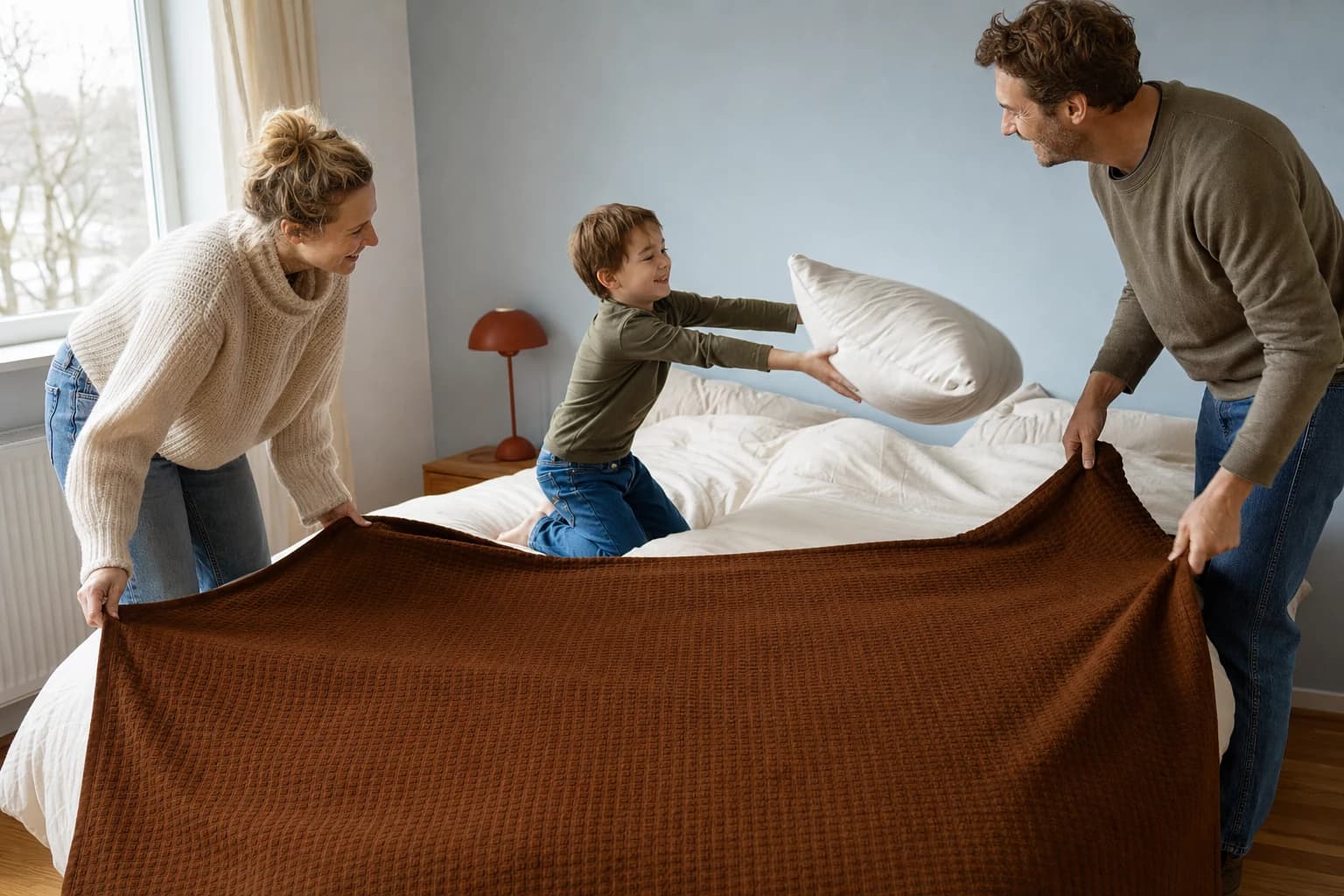 Familie legt eine braune Sorrent Veloursdecke als zusätzliche Lage über die Bettdecke