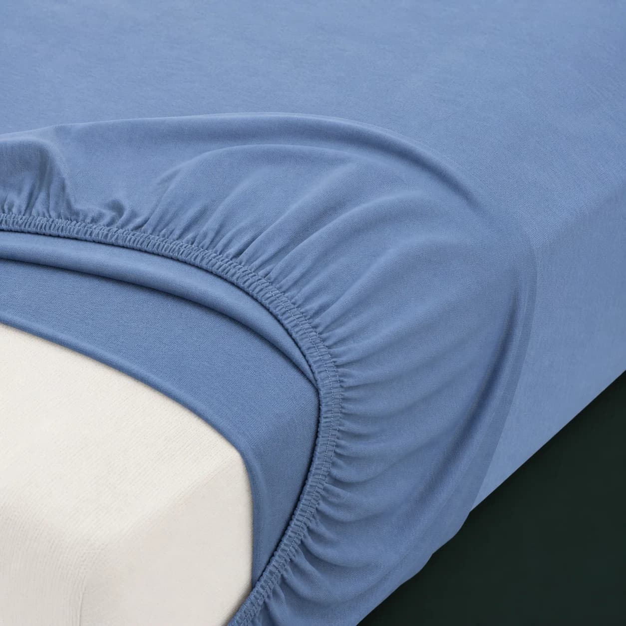 Nahaufnahme eines blauen Miami/Gina Spannbettlakens mit sichtbarer Ecke und Rundumgummi